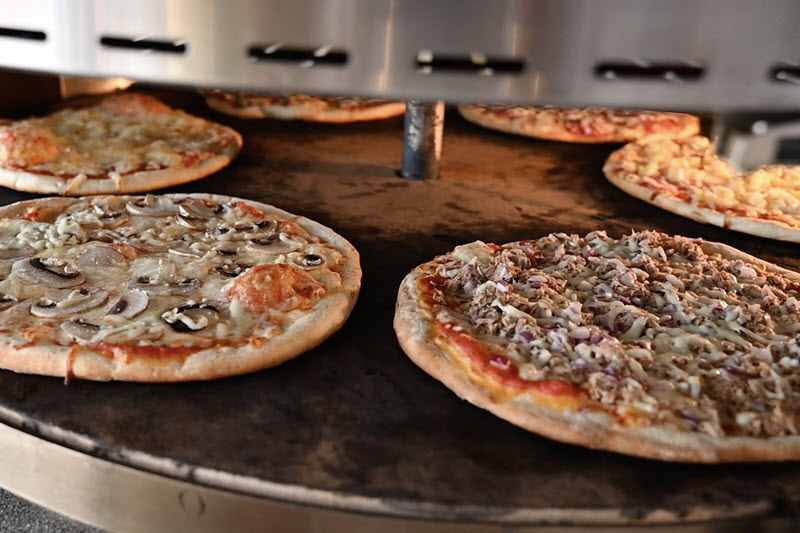 Verse pizza in de steenoven tijdens pizza catering in Venray